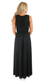 A woman viewed from the back wearing a sleeveless black maxi dress with a gathered pleated back and flowing skirt, photographed against a plain white studio background.